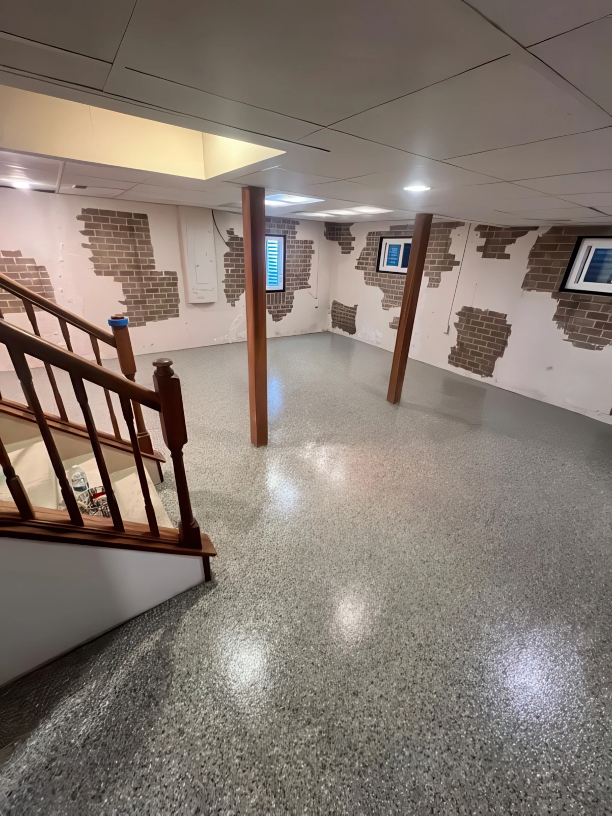Finished basement living room with a polished metallic epoxy floor coating